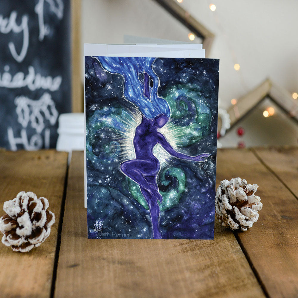 star goddess galaxy art card on table with pine cones